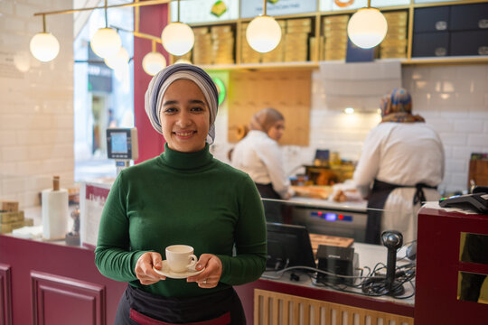 Muslim Cashier Posing in front of the Kitchen