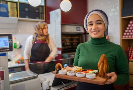 Muslim Cashier Posing in front of the Kitchen