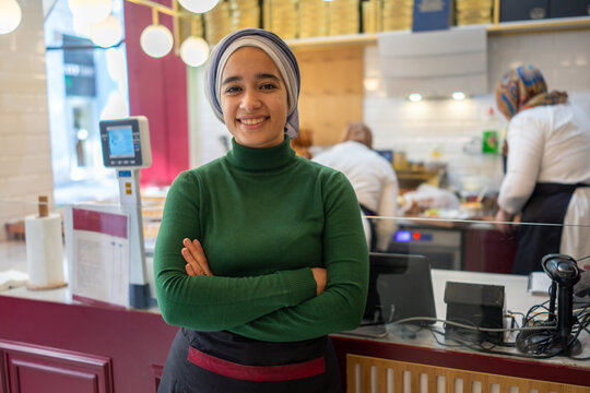 Muslim Cashier Posing in front of the Kitchen