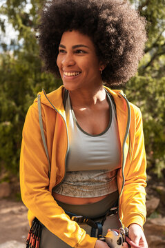 Woman rock climber with afro on belay
