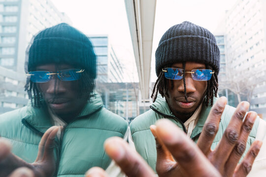 Stylish black man gesticulating at camera on street