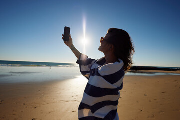 Woman captures a selfie on the shore