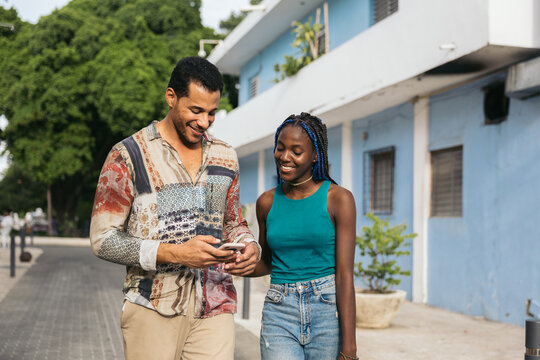 Friends watching content together on a smartphone outdoors