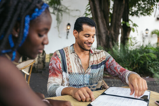 Friends on a terrace looking at the menu, deciding what to order.