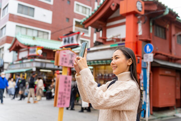 Happy Asian woman using mobile phone taking selfie during travel Sensoji Temple at Asakusa...