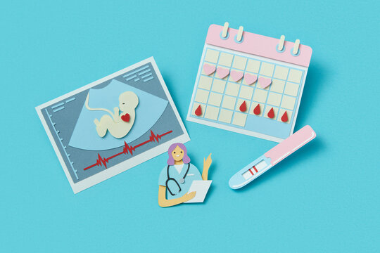 Paper doctor with ultrasound baby scan, calendar and pregnancy test