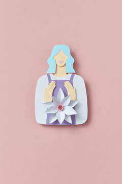 Colorful handmade paper woman holding white paper flower