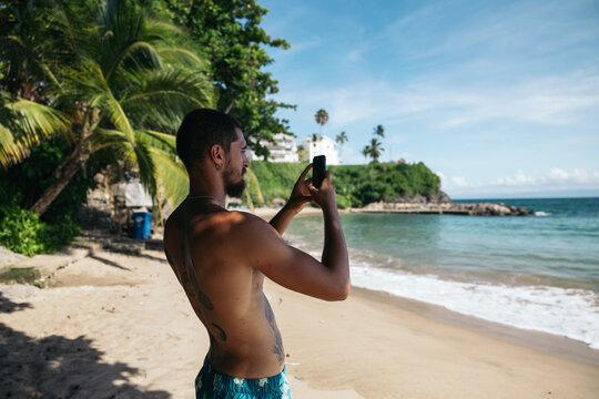 Man taking photos on a tropical beach in the Caribbean Sea