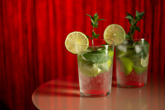 Classic rum mojito cocktail against red background