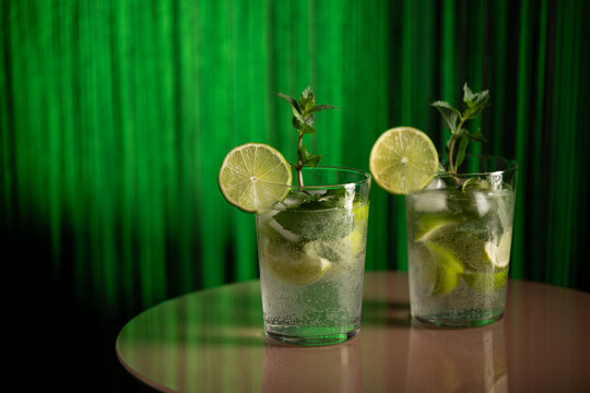 Classic rum mojito cocktail against green background