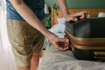 A man closing up the suitcase