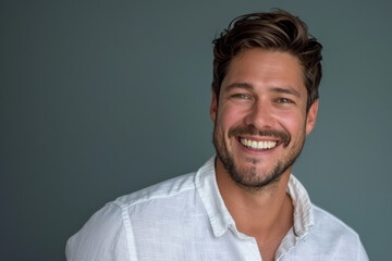 Fototapeta premium A man with a beard is smiling and wearing a white shirt