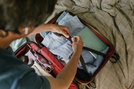 A man packing a suitcase on the bed