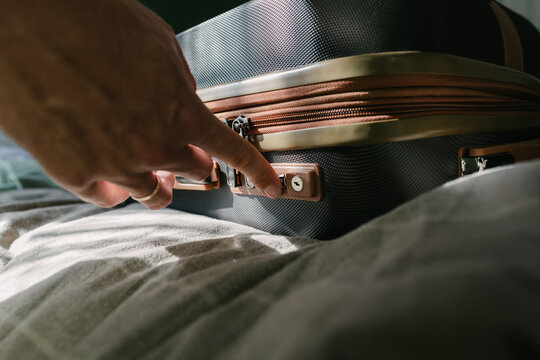 A man closing up the suitcase