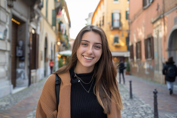 Fototapeta premium A woman smiles while walking down a cobblestone street
