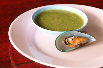 Mussels  on a  dish on red wooden table.