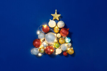 Flat lay pattern with Christmas balls and snowflakes on blue backgroun