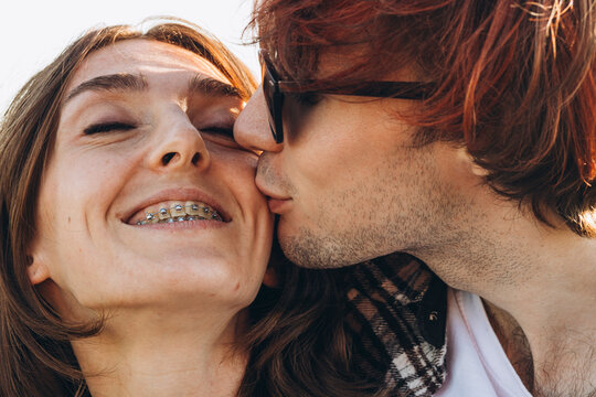 A boyfriend kissing his Happy girlfriend with braces