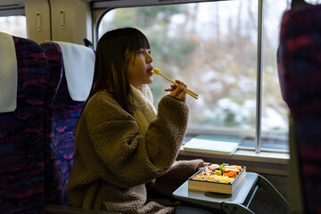 Asian woman eating traditional Japanese pork cutlet with rice Tonkatsu in lunch box bento during...