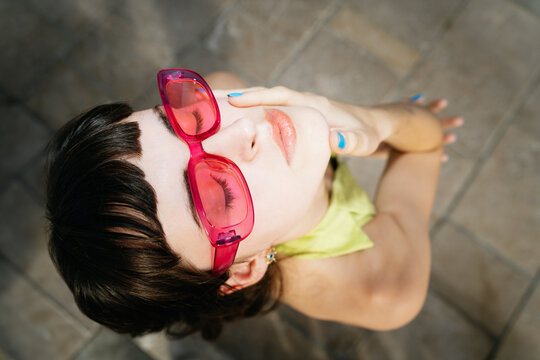 Woman closing her eyes in pink sunglasses