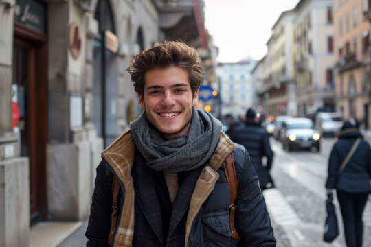 A young man wearing a scarf and a jacket smiles for the camera