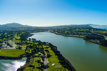 aerial shot of a beautiful spring landscape at Lake Merced with blue lake water and lush green...