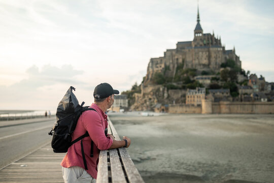tourist man contemplating mont saint michel in france