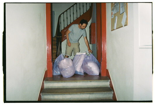 Man chores taking linen to the laundry