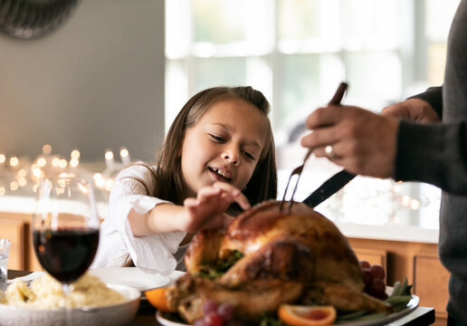 Thanksgiving: Gril Reaches To Get Bite Of Turkey
