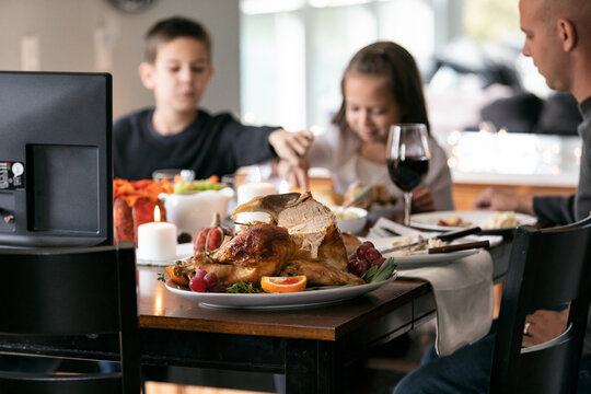 Thanksgiving: Carved Turkey On Platter With Family Eating