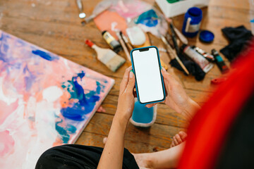 A woman is using a mobile phone in an art workshop