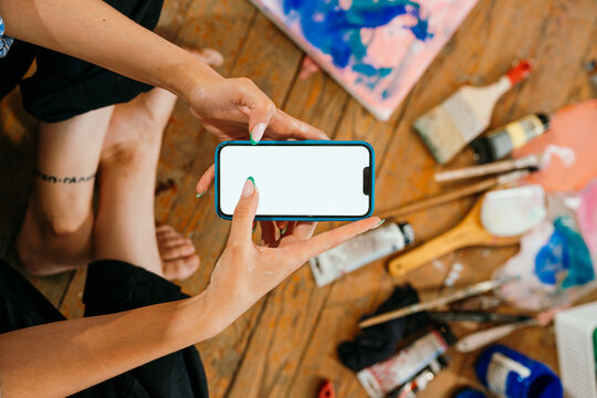 A woman is using a mobile phone in an art workshop