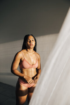 Portrait of a beutiful woman dressed in pale pink underwear.