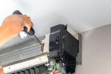 Technicians man using screwdrivers service for repair and maintenance of air conditioners, Repairman fix air conditioning systems