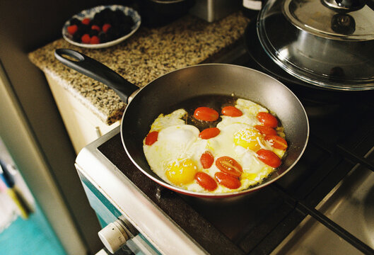 Eggs with cherry tomatoes on the frying pan