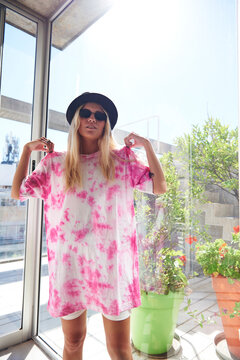 Blonde girl wearing a pink batik Tshirt.