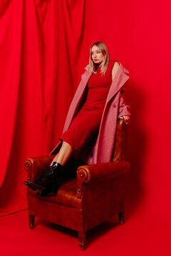 Fashionable stylish young lady in red dress with pink long coat