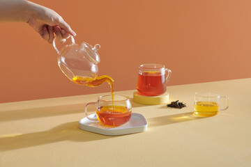 Hot water is poured from the kettle into a cup with tea leaves