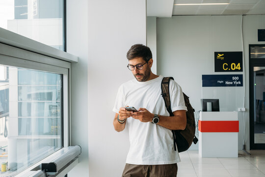 Portrait of Young Handsome Man With Mobile Phone at Airport 