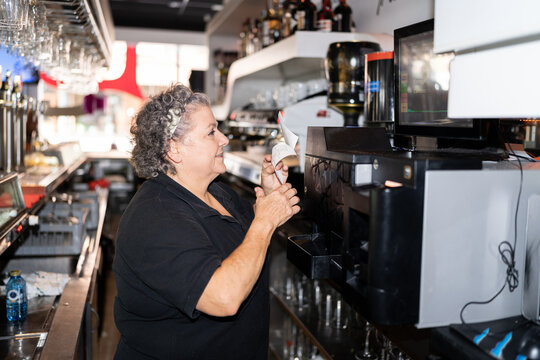Woman checking the order at bar.
