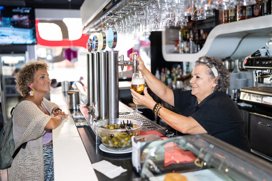 Mature woman working in bar.
