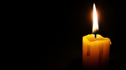 Gothic style burning candle on black background with ample space for text placement