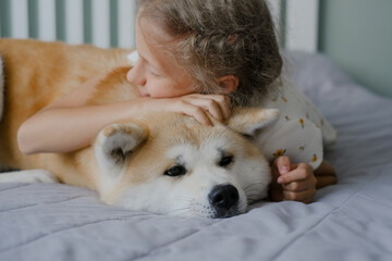 Teenage girl hugs her dog Akita ina