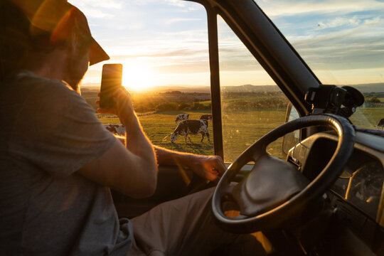 Man driving at sunset takes photo