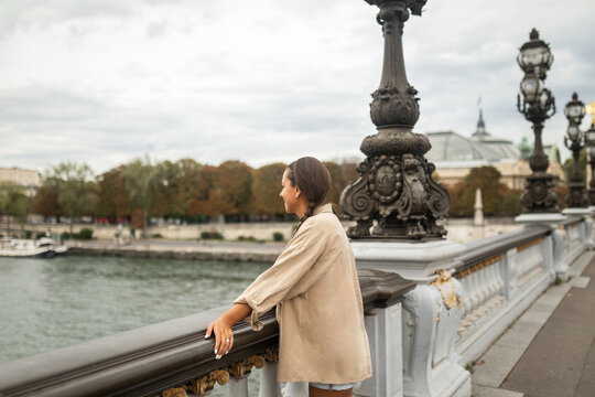 woman leaning on a bridge in paris in france