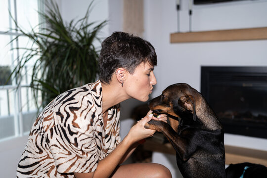 Loving woman with her dog at home.
