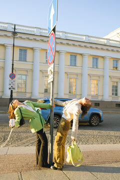 two crazy friends posing near road sign