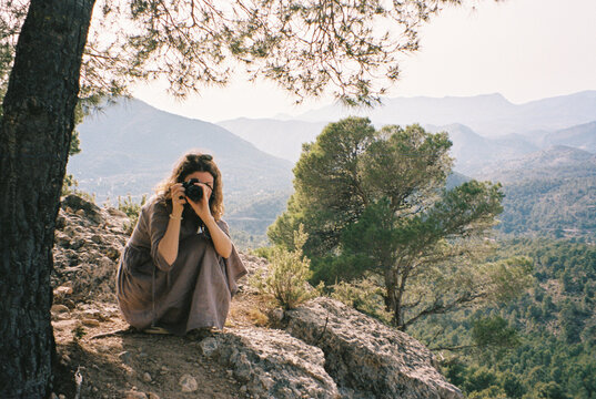 Young woman making photo on camera while hiking