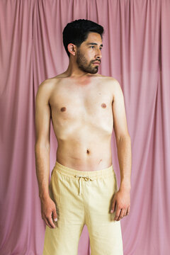 Medium shot portrait of a very thin bearded young man