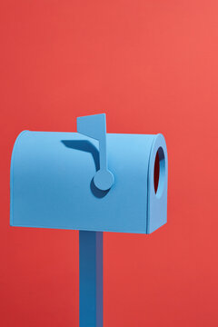Blue envelope in mailbox in a snow on red background